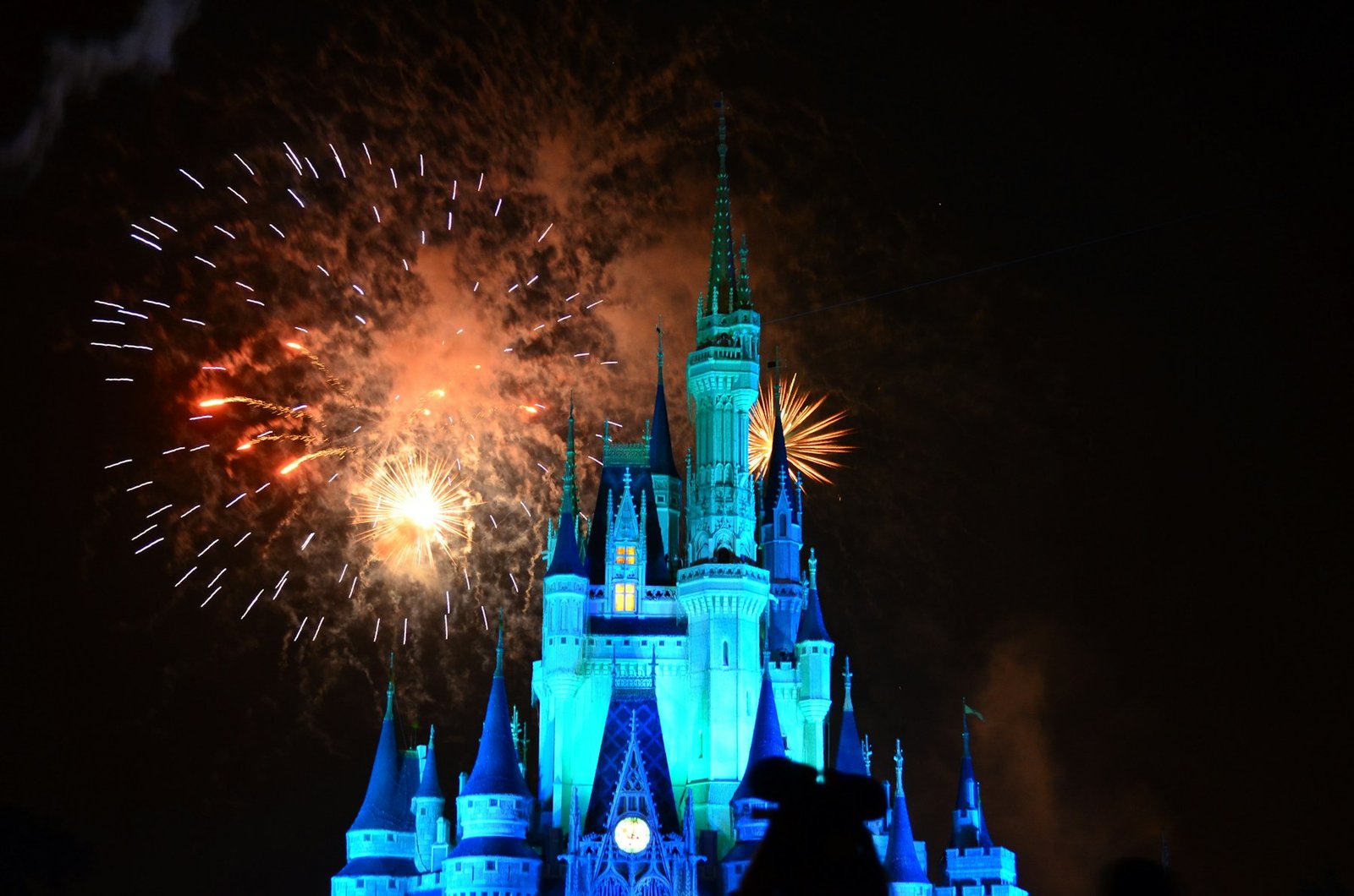 Disney castle illuminated by fireworks