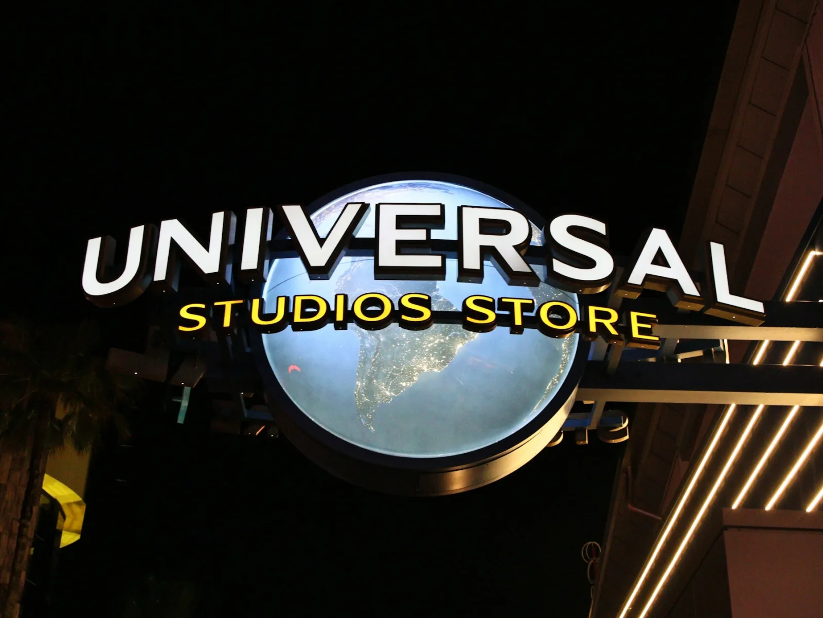Universal Studios sign and globe glowing at night in Orlando
